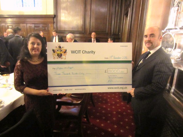 AbilityNet Trustee Nishita Sharma receives a large cheque from Mr Alan O'Connor who is Beadle for the Worshipful Company
