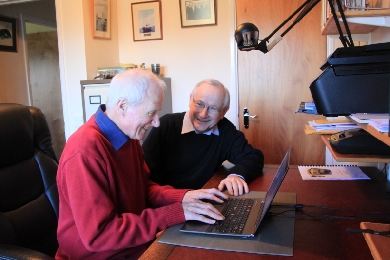 Photo. A Tech Volunteer provides free tech support to an older person in his home.