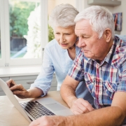 two older people using a computer together