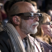 close up of man in sixties wearing smart caption glasses at theatre