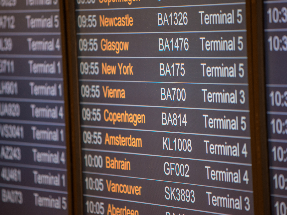 A close up of a flight departure board in an airport.