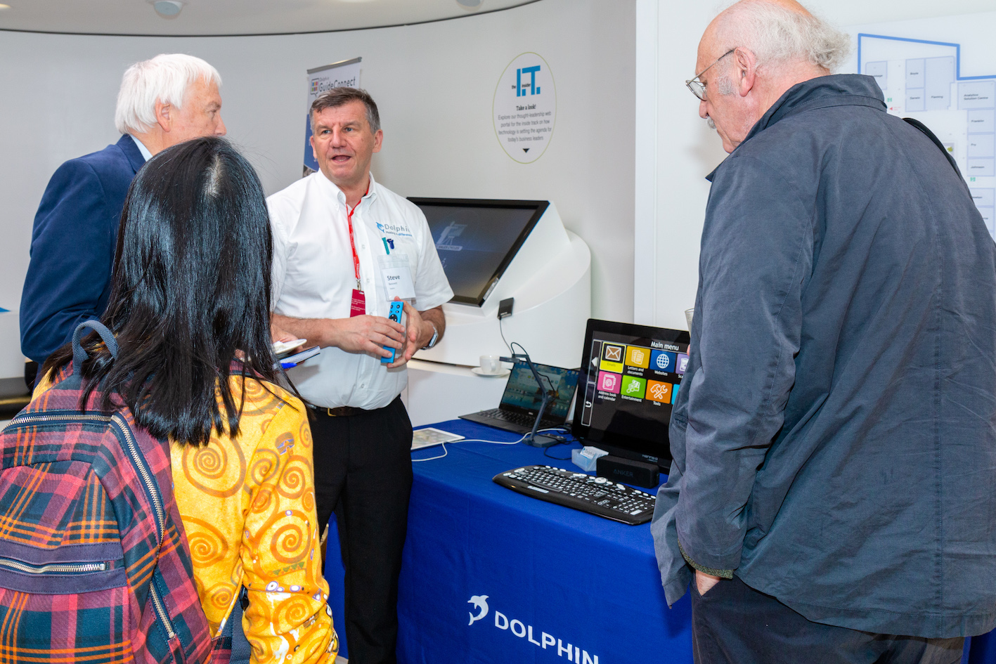 A representative from Dophin demonstrating their assistive tech to event attendees