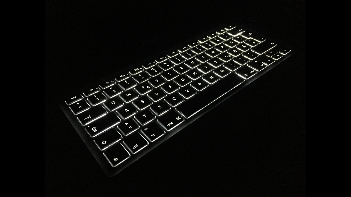 A black keyboard on a black background with keyboard lit up