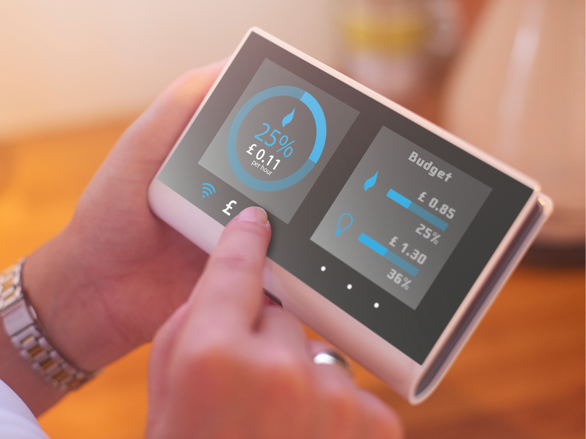 Hands holding and touching a smart meter
