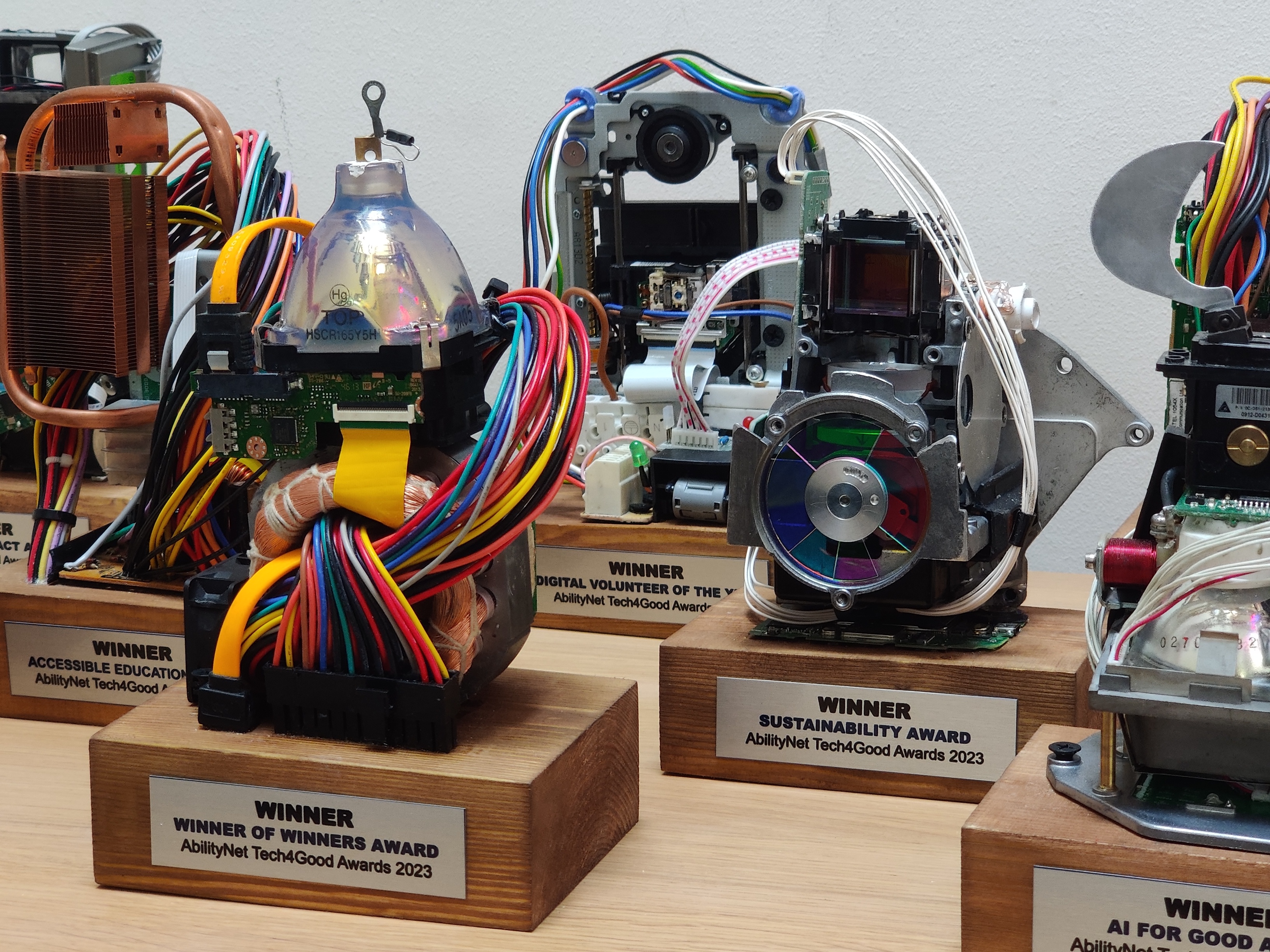 A selection of trophies made from recycled computer parts are displayed on a table. 