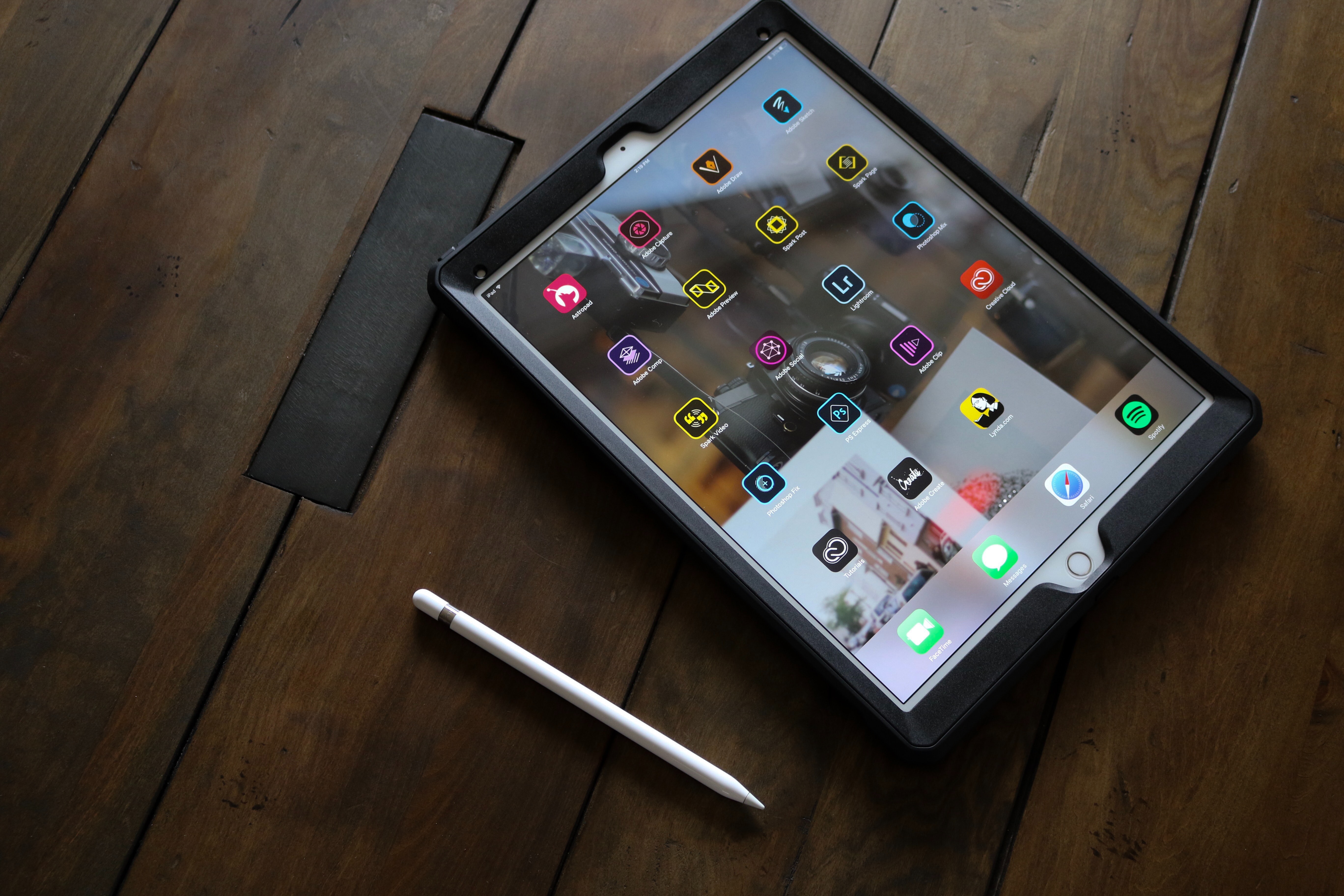 A tablet and a stylus on a wooden table