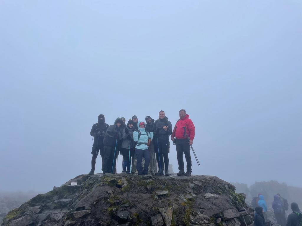 Group of people on top of foggy peak in climbing gear