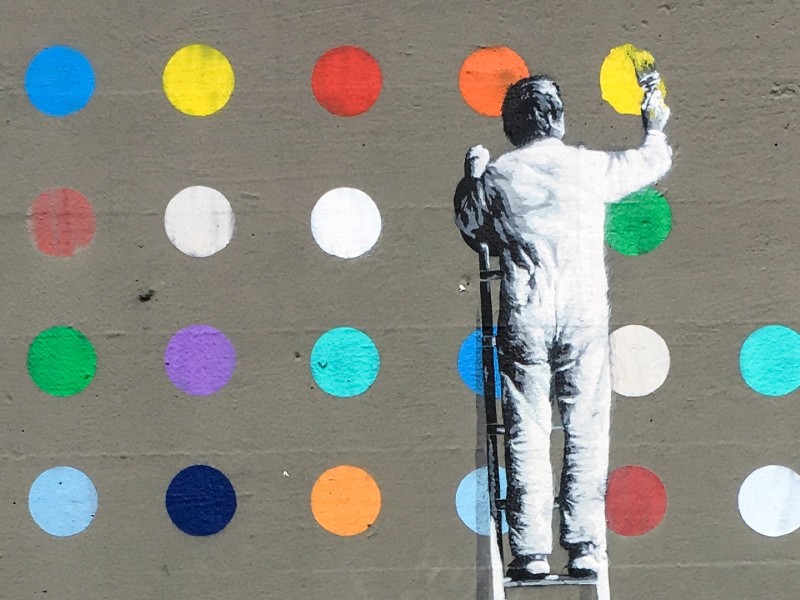 Image of man painting dots on a wall