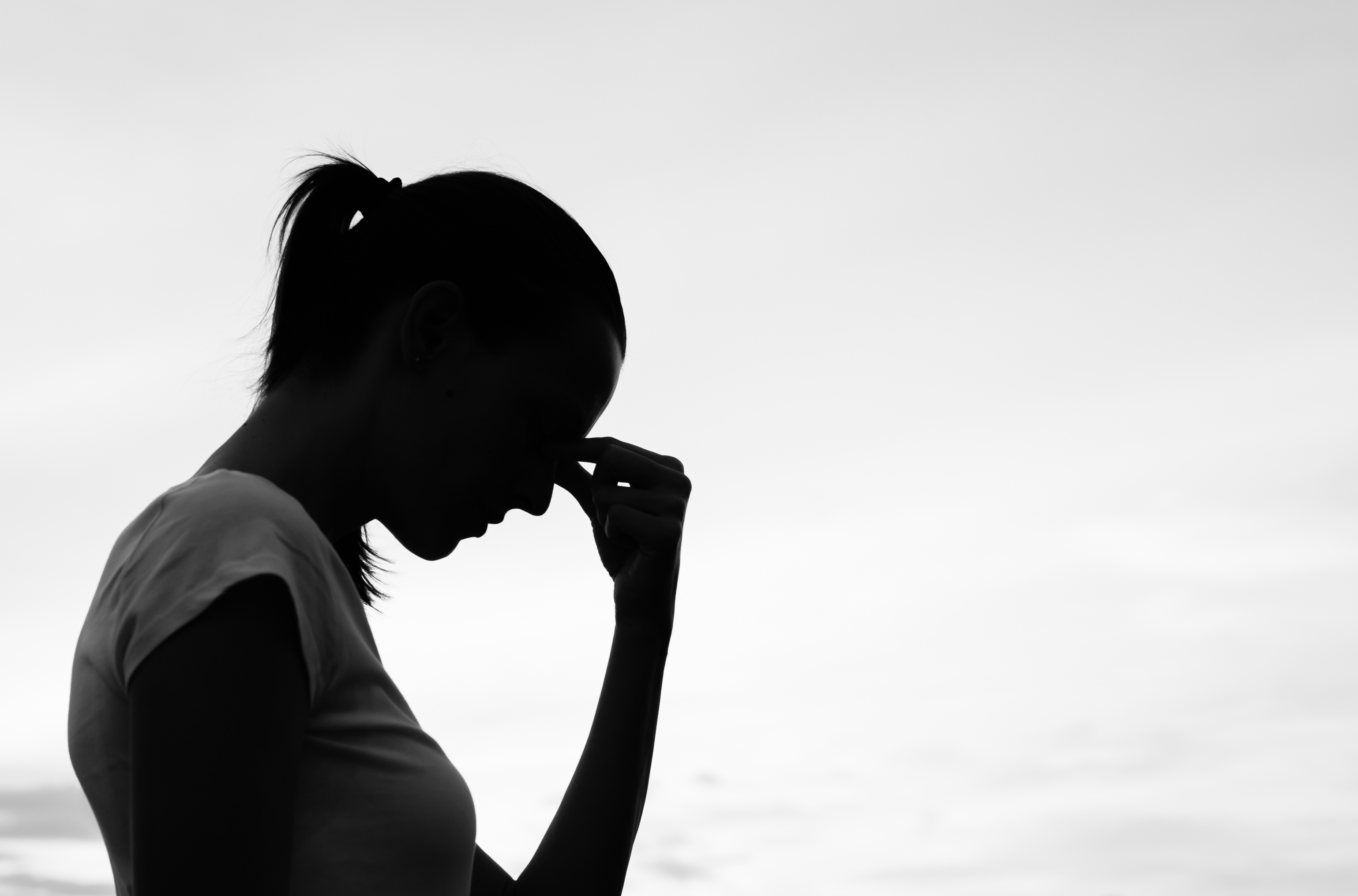 silhouette of a woman looking troubled