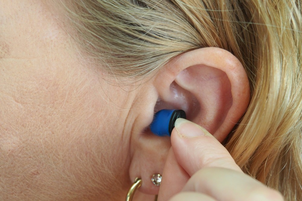 Woman with earplug in ear