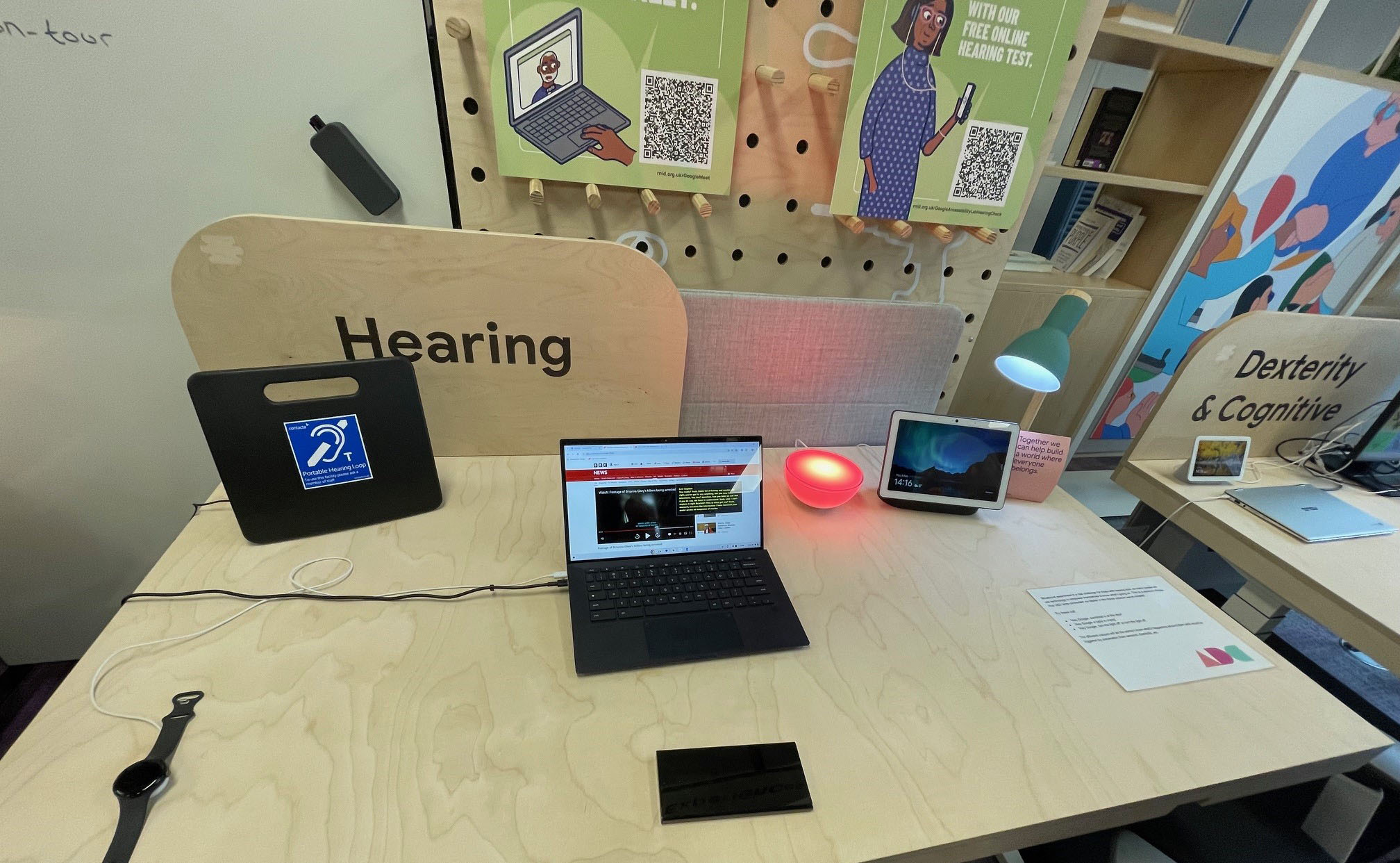 Hearing and 'Dexterity and cognitive' lab desks with lots of digital devices on display on a desk