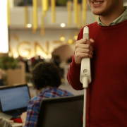 man smiling uses WeWALK smart cane at office