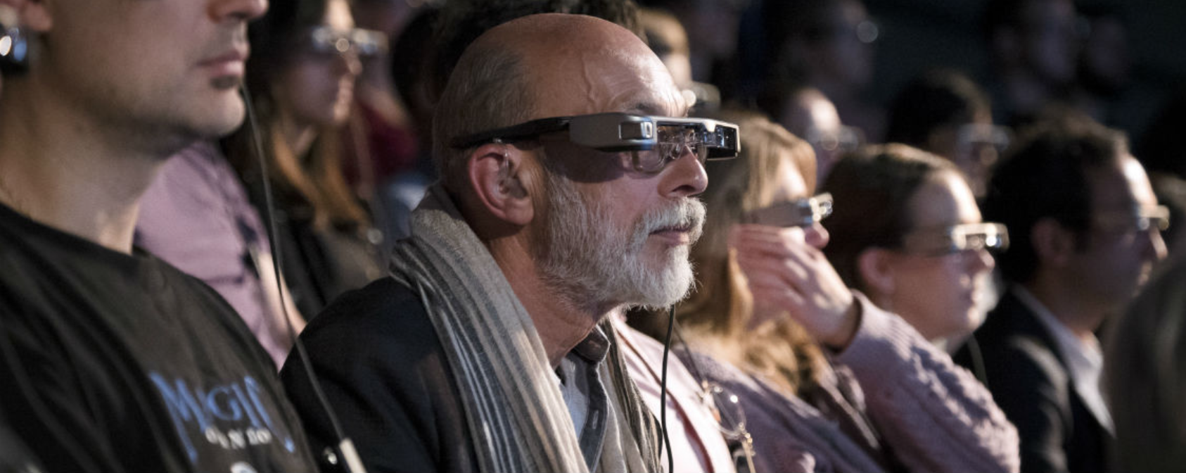 theatre audience wearing smart caption glasses