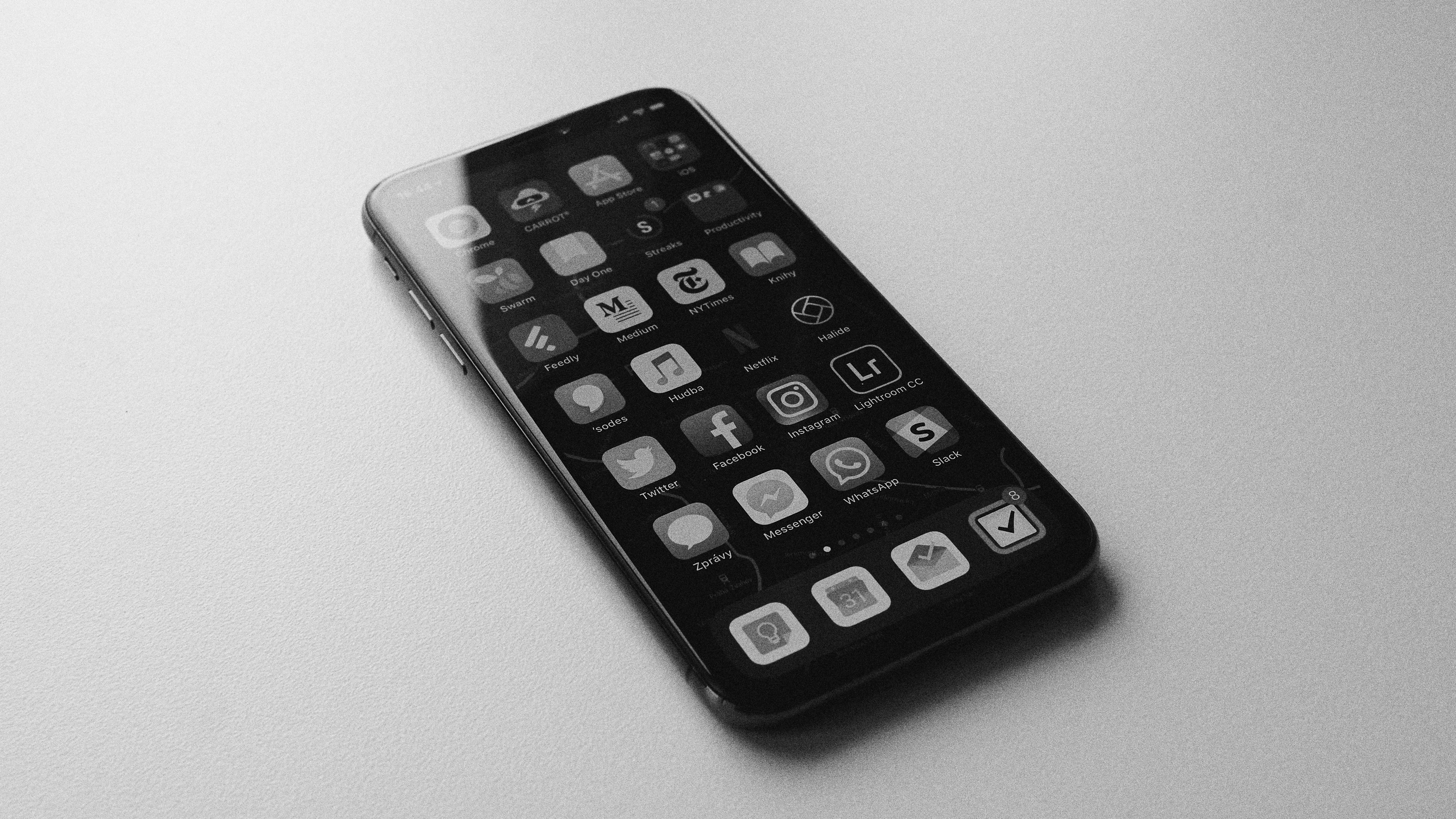 A black and white image of a smartphone with app icons on screen