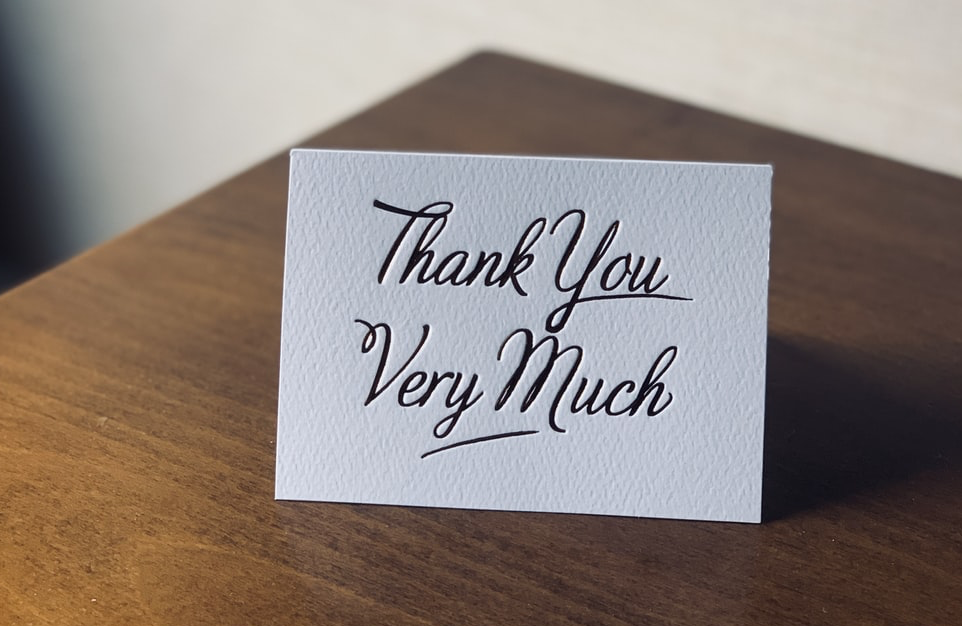 a thank you card sat on a wooden table