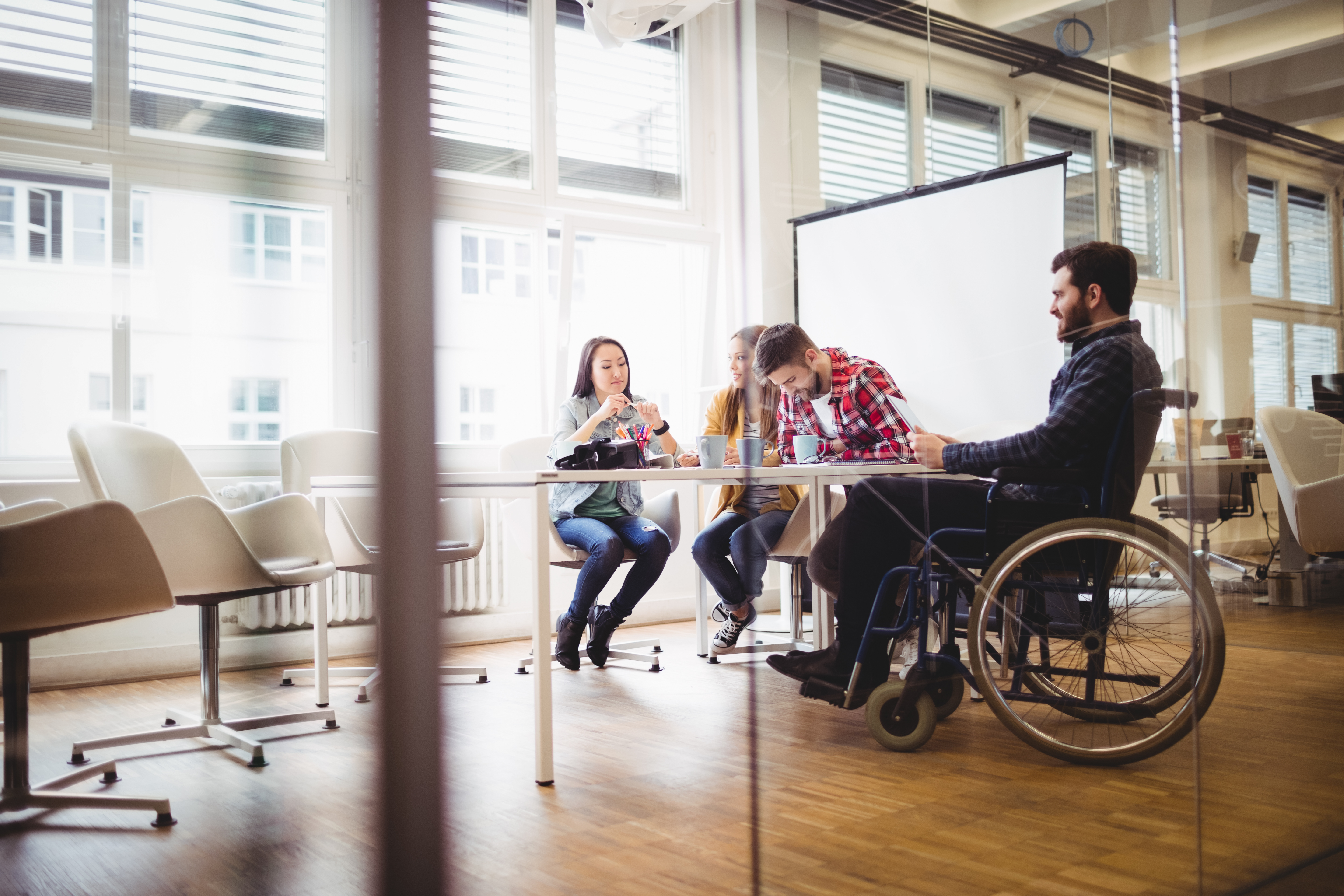 office setting with man in wheelchair looking positive